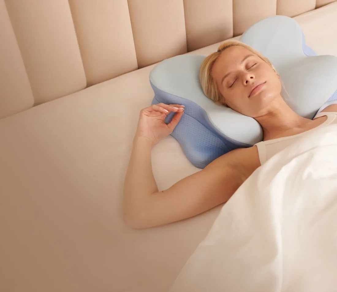 Woman sleeping on her back on the Derila Ergo pillow in a calm bedroom
